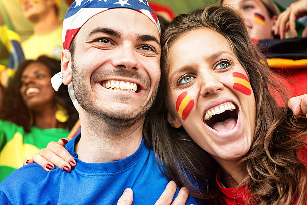 istock Supporters. German and American Fans embraced in foreground 187037348
