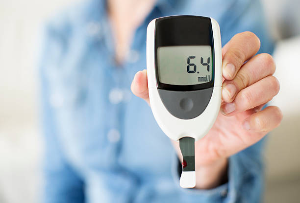 woman showing her glucose level test. - glükomere stok fotoğraflar ve resimler