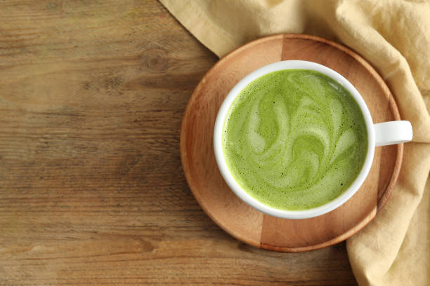 istock Cup of aromatic matcha latte on wooden table, top view. Space for text 1870378941