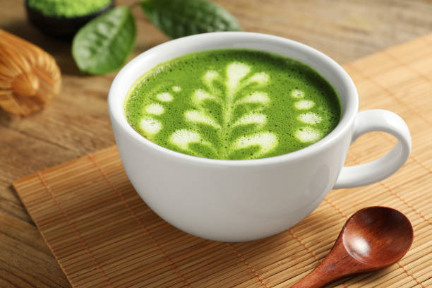 istock Delicious matcha latte in cup and spoon on wooden table, closeup 1870379481