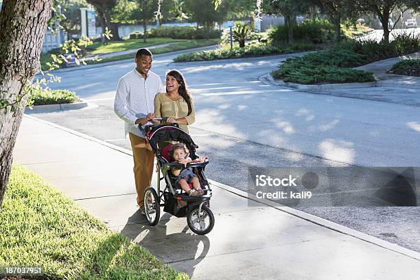 Giovane Famiglia Con Bambino Nel Passeggino - Fotografie stock e altre immagini di Padre - Padre, Passeggino, Spingere