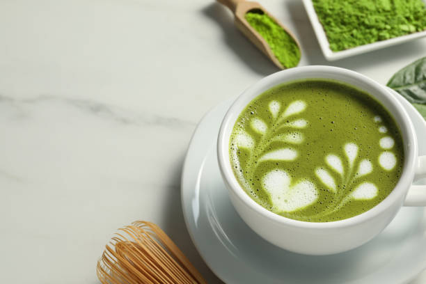 istock Delicious matcha latte in cup on white marble table. Space for text 1870381075
