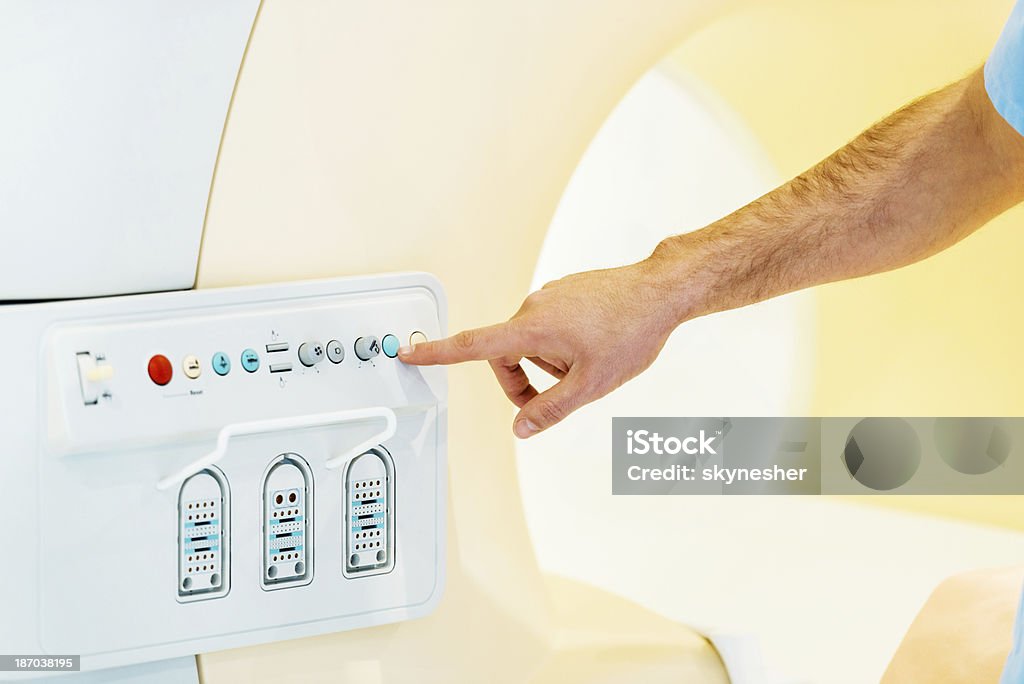 Pressing the start button on MRI Scan. Close up of an unrecognizable person who is about to press the start button on MRI Scan.    Adult Stock Photo