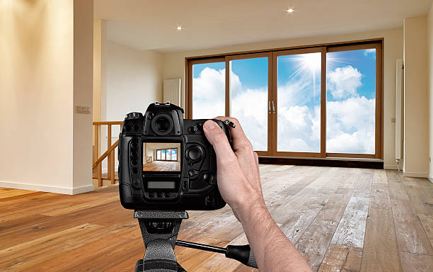 istock Man photographing empty living room with digital camera 187039052