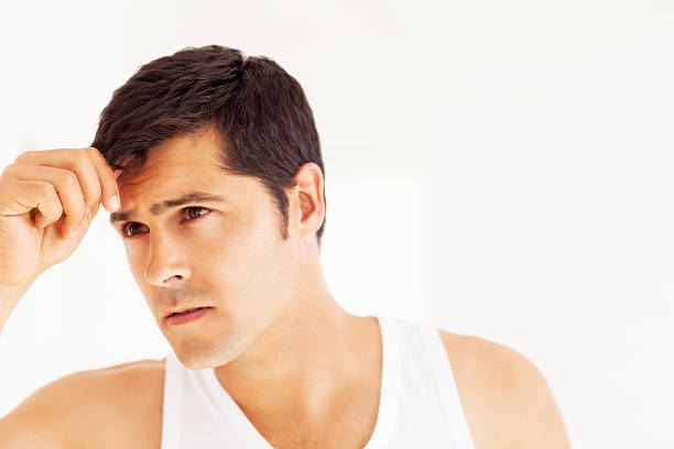 istock Young Man Checking Hair In The Mirror 187039349