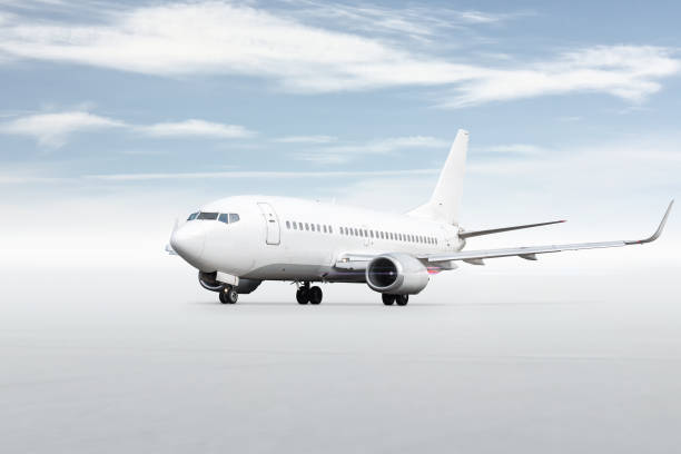 istock White passenger airplane isolated on bright background with sky 1870395718