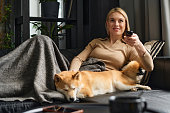 Woman Enjoying Watching Television with Her Dog