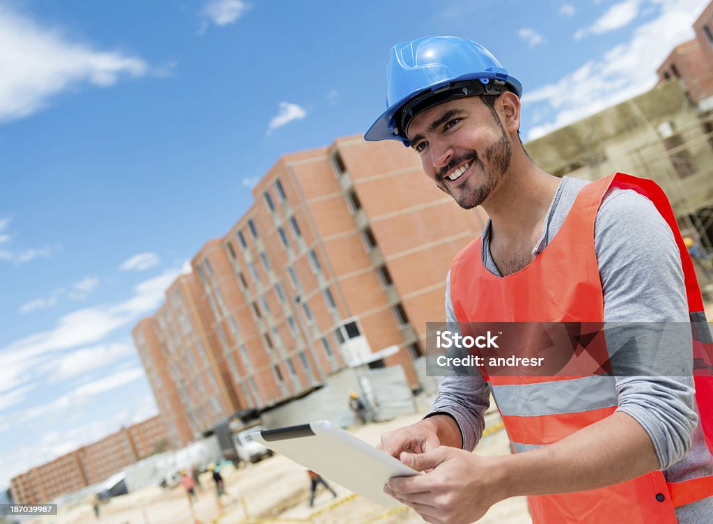 Trabajador de la construcción en un sitio de construcción - Foto de stock de Accesorio de cabeza libre de derechos