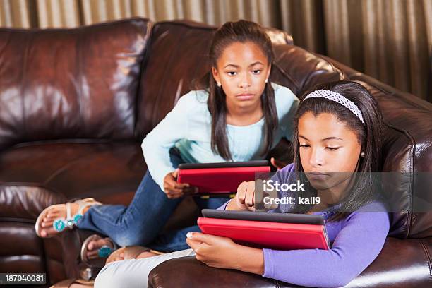 Duas Crianças Afroamericana Em Casa Usando Digital Comprimidos - Fotografias de stock e mais imagens de Família com Dois Filhos
