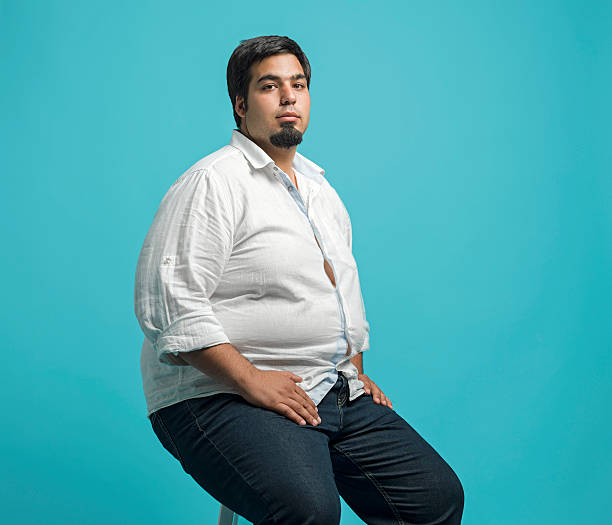 Overweight young man Portrait of overweight young man, studio shot chubby arab stock pictures, royalty-free photos & images