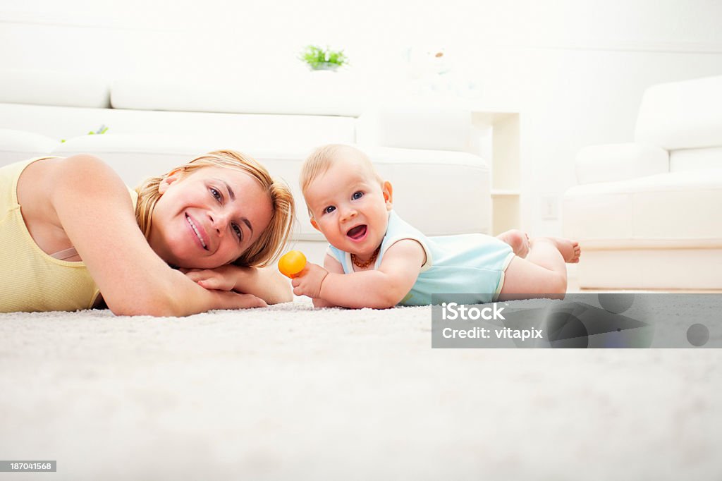 Madre y bebé jugando en la sala de estar de la suite white - Foto de stock de Bebé libre de derechos