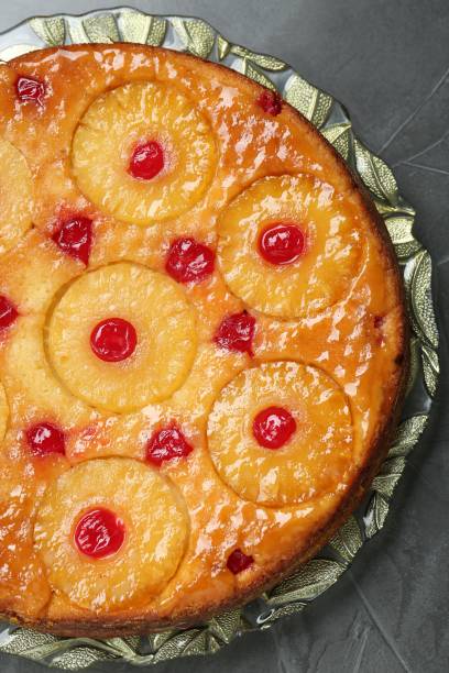 istock Plate with tasty pineapple cake on grey textured table, top view 1870418556