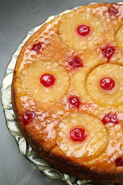 istock Plate with tasty pineapple cake on grey textured table, closeup 1870419078