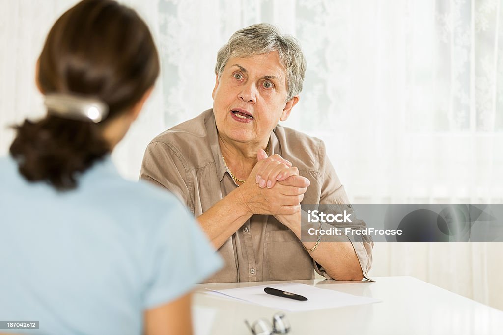 Mujer mayor y psiquiatra - Foto de stock de Angustiado libre de derechos