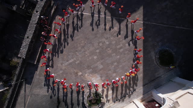 Birdseye Aerial View, Majorette Girls in Red Uniforms Performing on City Square. Top Down Drone Shot