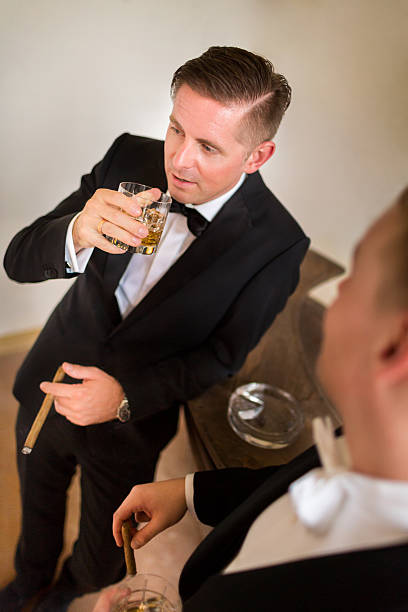 sposo diverte sigaro con testimone di nozze - cigar whisky men smoking foto e immagini stock