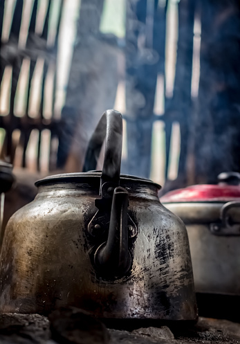 Rural traditional kitchen in an adobe house in the village of San Juan de Chuccho, Colca Canyon, Peru. Kettle on fire on an earth oven. Steam.