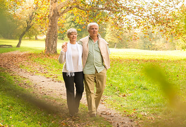 istock Senior Couple Walking In Park 187044801