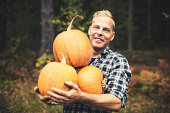 Handsome man outdoors with pumpkins