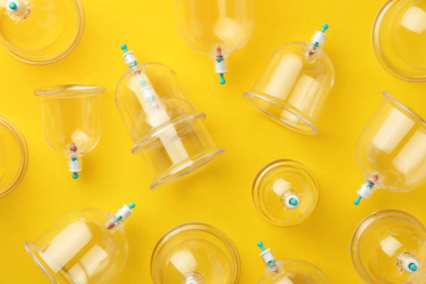 istock Plastic cups on yellow background, flat lay. Cupping therapy 1870455465