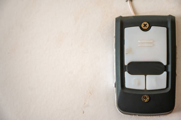 istock Drywall with a mounted garage door opener control panel. 1870457064