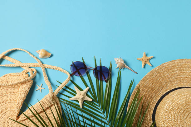 istock Flat lay composition with wicker bag, palm leaves and other beach accessories on light blue background. Space for text 1870458640