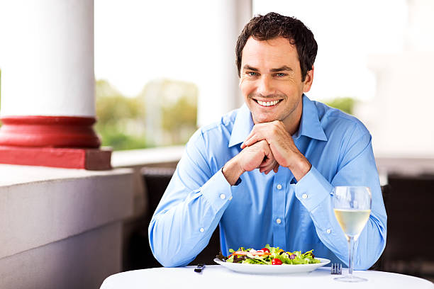 istock Man With Wineglass And Salad Sitting At Restaurant 187046575