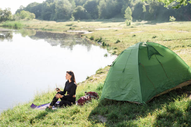 istock Sport girl sit on lake coast and drinking tea 1870472923