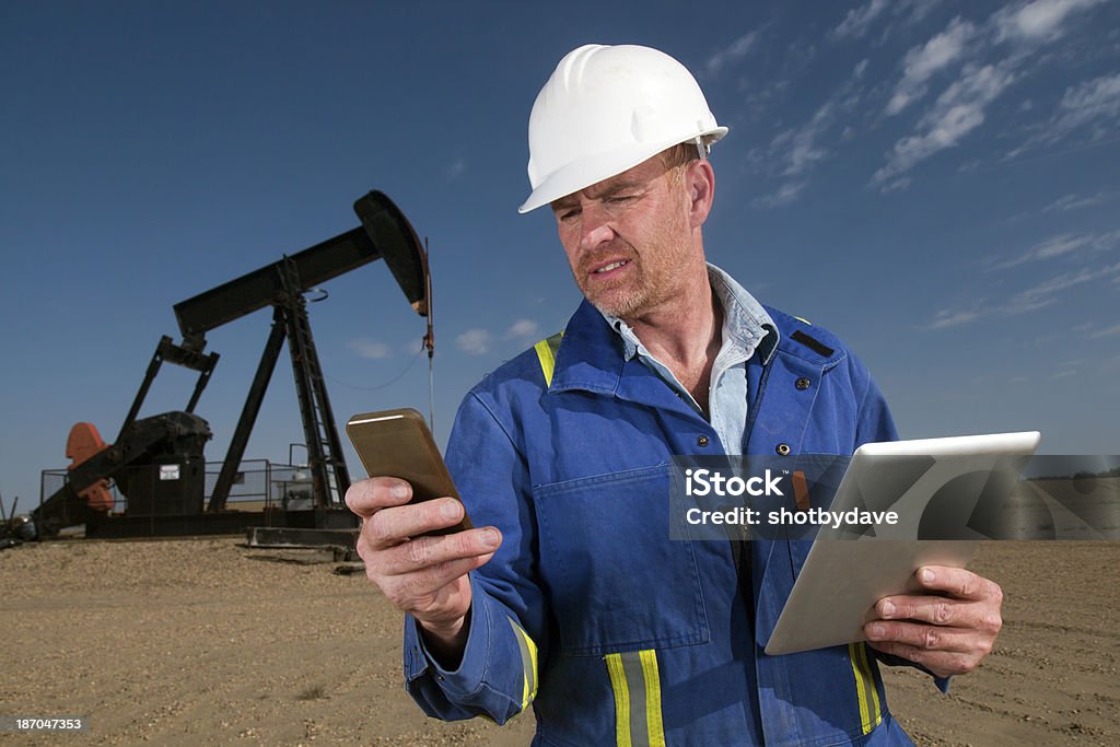 Multitarea trabajador del petróleo - Foto de stock de Derrame de petróleo libre de derechos