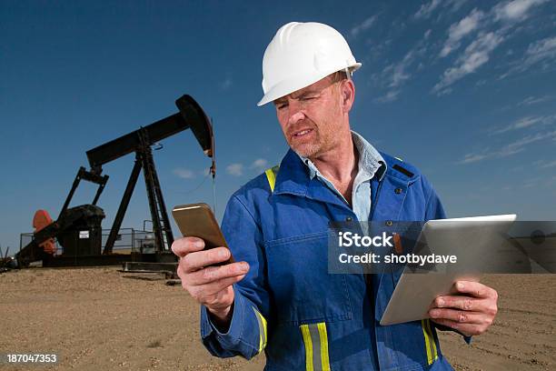 Multitarea Trabajador Del Petróleo Foto de stock y más banco de imágenes de Derrame de petróleo - Derrame de petróleo, Teléfono inteligente, Accesorio de cabeza