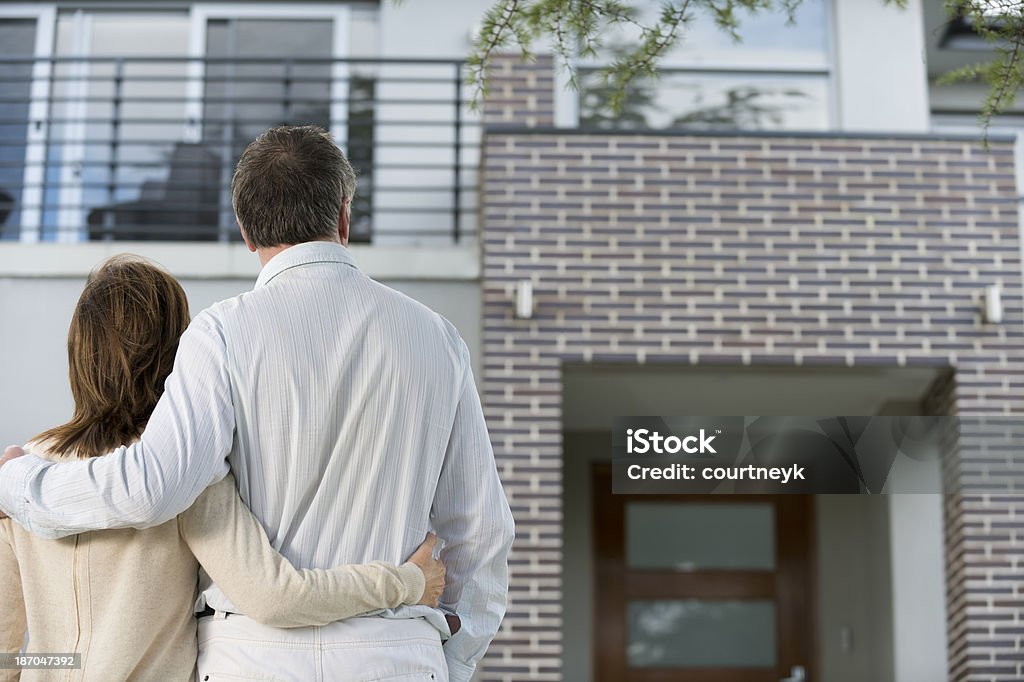 Mature couple looking at a house Mature couple looking at a house. Rear view House Stock Photo