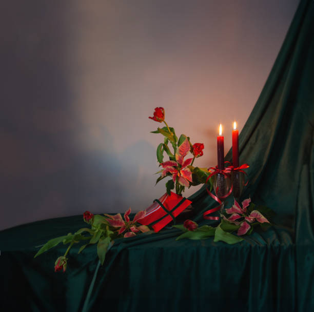 świąteczna dekoracja z czerwonymi tulipanami, poinsecją i płonącymi świecami - poinsettia christmas candle table zdjęcia i obrazy z banku zdjęć