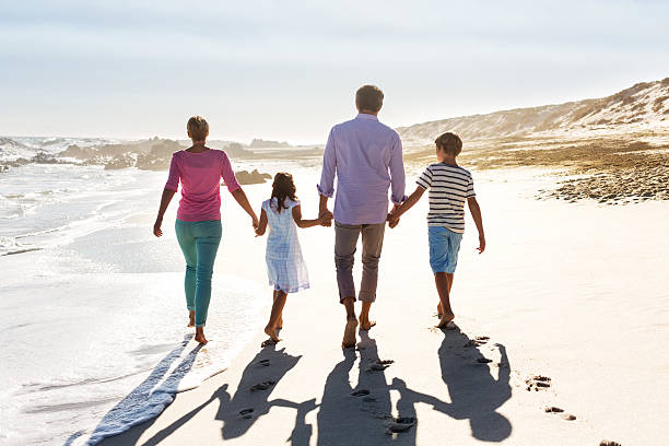istock Parents And Children Holding Hands While Walking On Beach 187048728