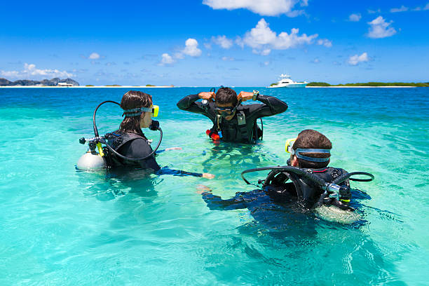 Scuba diving. Beautiful sea. Scene with happy female scuba divers into the sea, preparing to dive,  enjoy  in  turquoise, blue lagoon, shallow water. Over, under sea, split shot, half-half underwater turquoise lagoon.