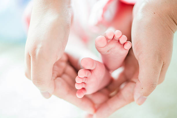 istock Parent Holding Baby's Feet 187049404
