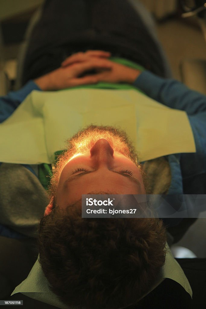 Hombre joven en de dentista con un relleno de diente - Foto de stock de Dentista libre de derechos