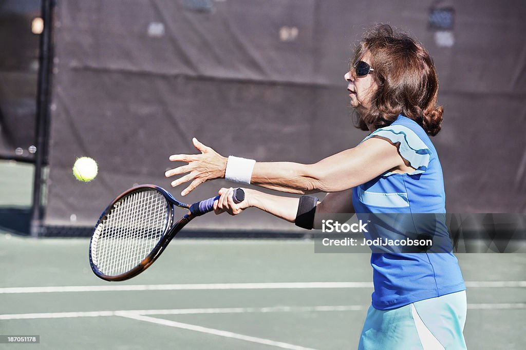 年配の女性テニスボールを訪れる - アクティブシニアのロイヤリティフリーストックフォト