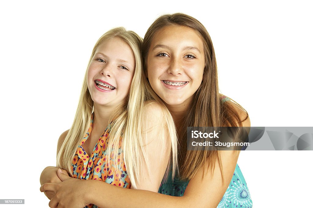Magnifiques jeunes soeurs avec bretelles se tenant sur blanc Bacgkround - Photo de Appareil dentaire libre de droits