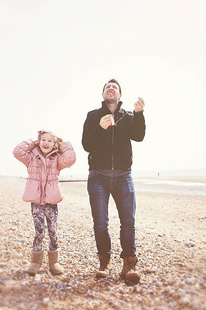 istock Father and Daughter Playing on Beach with Kite 187051890