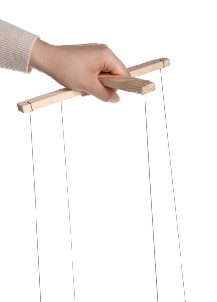 istock Woman pulling strings of puppet on white background, closeup 1870519883