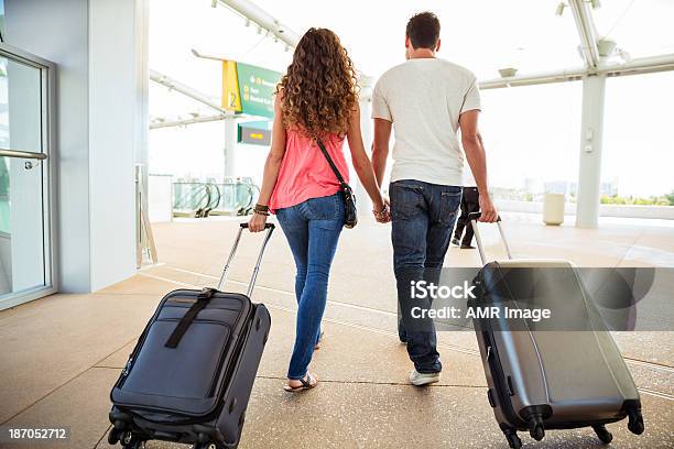 Attraktives Paar In Einem Flughafen Mit Koffer Stockfoto und mehr Bilder von Flughafen - Flughafen, Paar - Partnerschaft, Hände halten