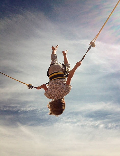 istock Eight Year Old Girl Trampolining Against a Summers' Sky 187052838