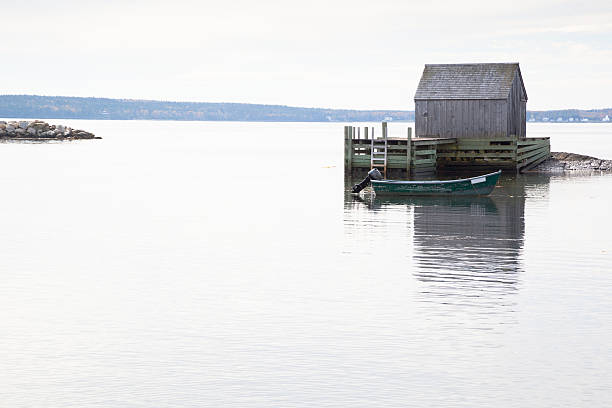 istock fishing boat at anchor by boathouse jetty 187053300