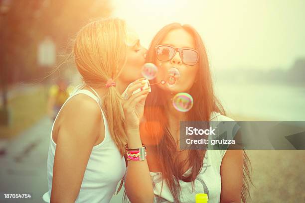 Two Cheerful Friends Having Fun And Blowing Bubbles Stock Photo - Download Image Now