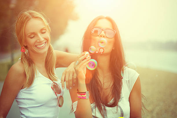 istock Two cheerful friends having fun and blowing bubbles 187054773