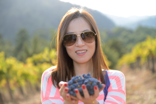 Smiling woman in vineyard. Selective focus. 