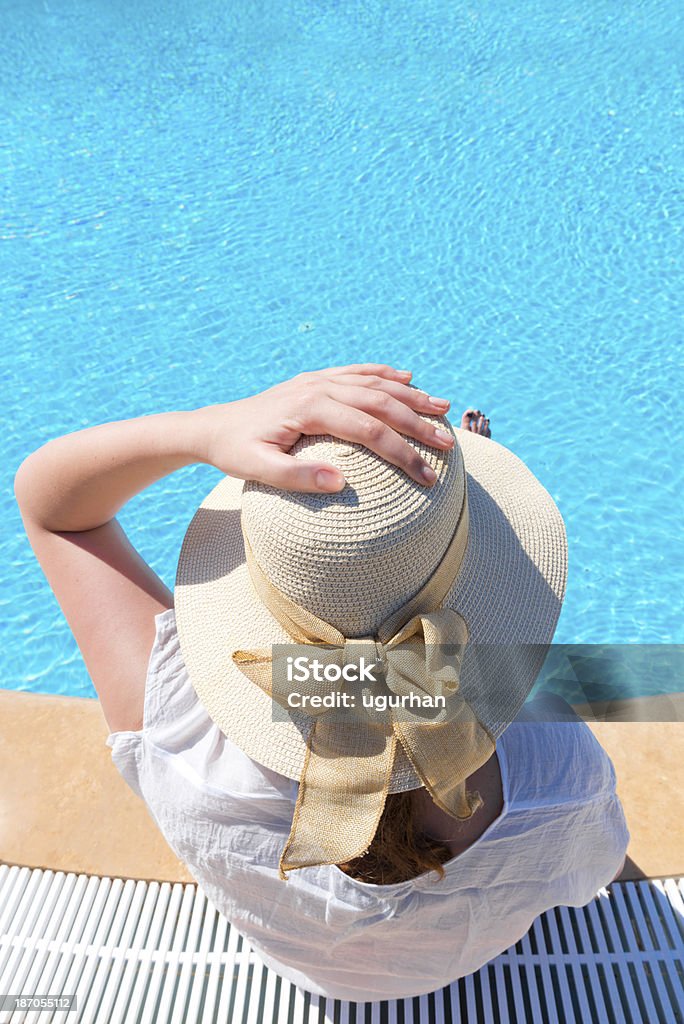 Swimming pool Sunhat women in blue pool. Adult Stock Photo