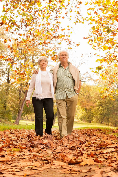 istock Senior Couple Walking In Park 187057327
