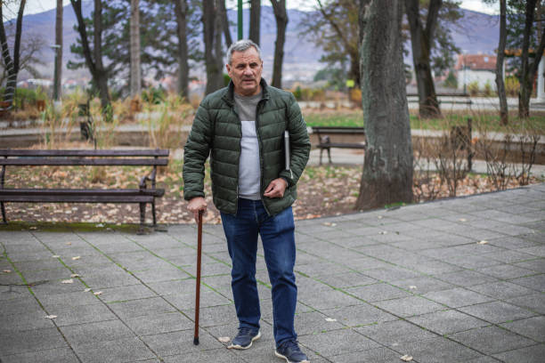 An elderly man walks in a public park, a recreational pursuit