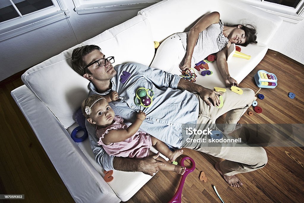 Baby Girl on a Messy Couch with her Parents This is a photo relating to everyday life. Chaos Stock Photo